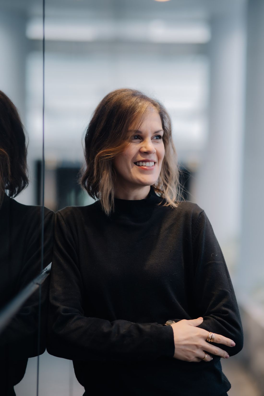 Rebbeca Rödel, fundadora da Lazarus Solutions, sorrindo, de braços cruzados, encostada numa parede de vidro